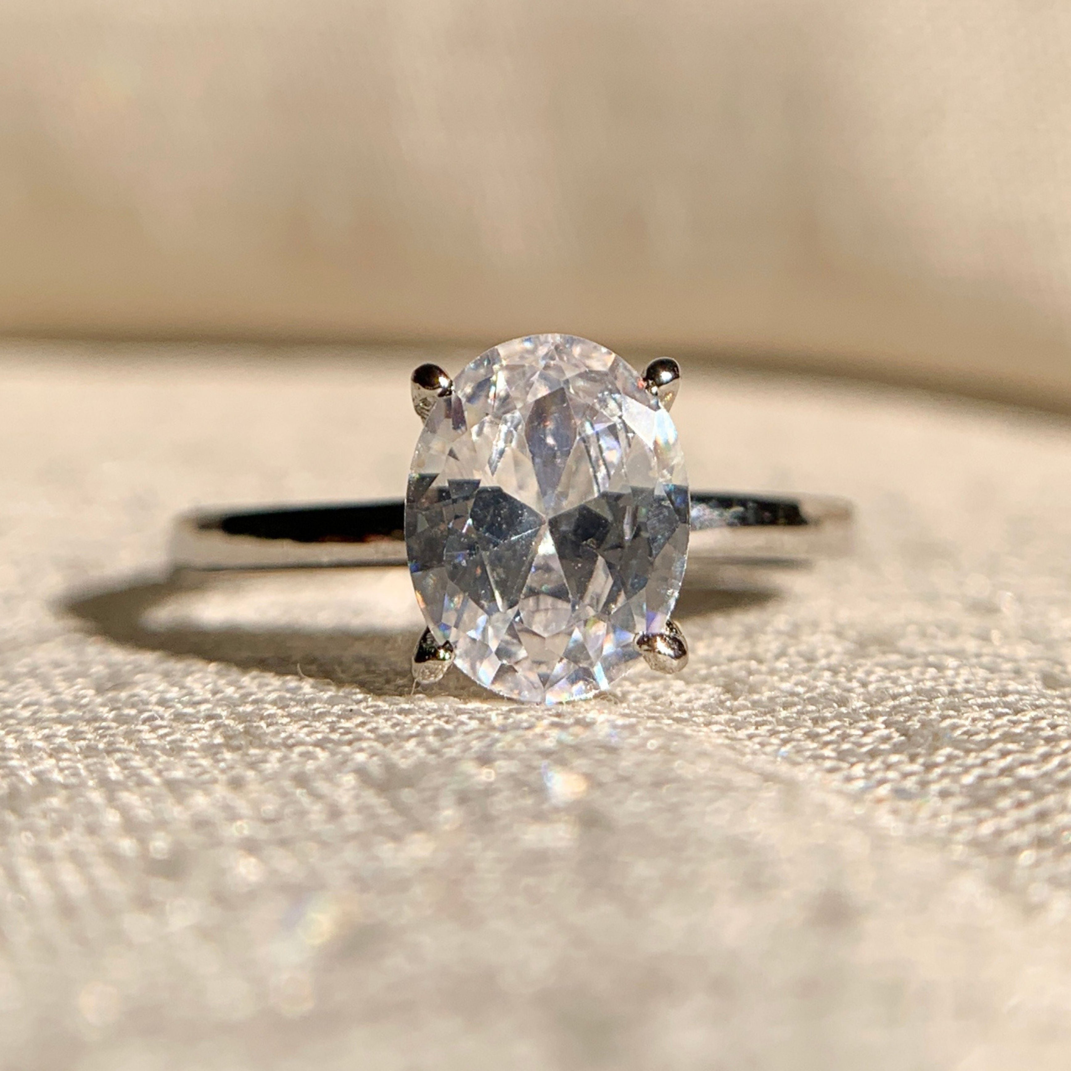 1.0 CT oval solitaire engagement ring in sterling silver on white background